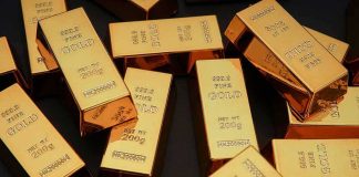 Gold bars stacked and scattered on a dark surface