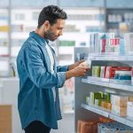 Man shopping in a pharmacy aisle