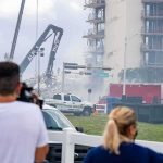 Rescue crews and cranes clear debris at a damaged high-rise building