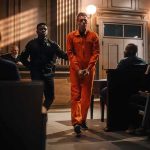 A Courtroom Fight Over Murder And Psychosis Inmate in orange jumpsuit escorted by officer in courtroom