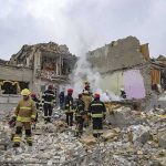 Firefighters search rubble of a partially collapsed building