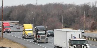 Convoy of semi trucks driving on a multi-lane highway