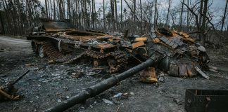 Destroyed tank lying in pieces on a forest road