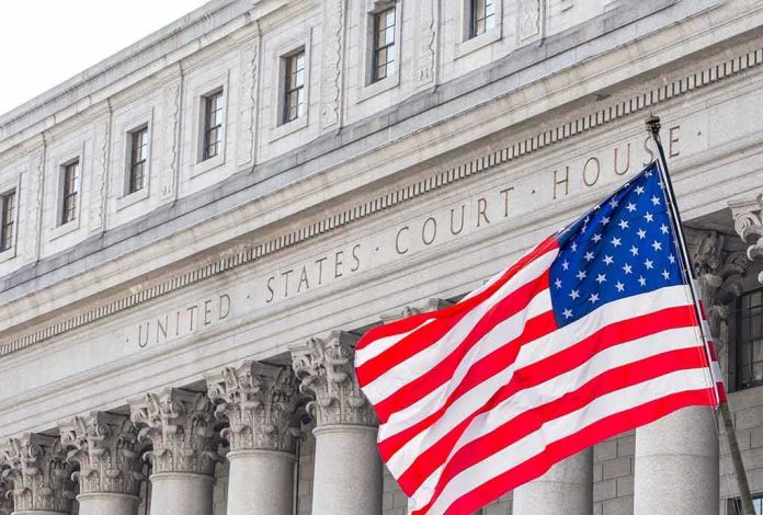 shutterstock_2231108363 American flag waves in front of a United States courthouse facade