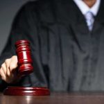 Judge with gavel striking sound block