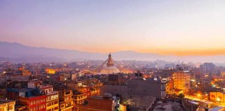 Buddhist stupa rising over a city at dusk