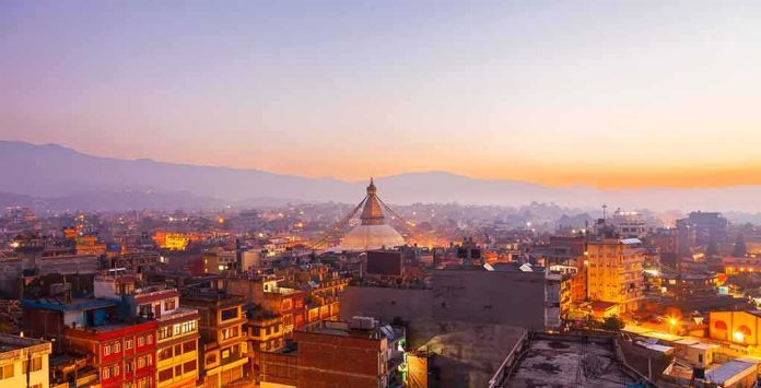shutterstock_2261333387 Buddhist stupa rising over a city at dusk