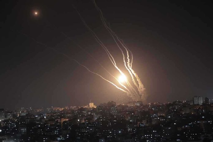shutterstock_2301205711 Night sky above a city with multiple rockets arcing and bright explosions