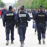 Police officers walking in a park among pedestrians
