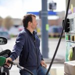 Man refueling a car at a gas station pump