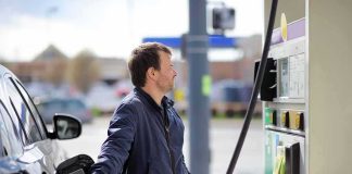 Man refueling a car at a gas station pump