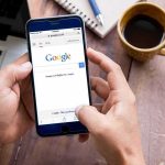 Judge Nails Google Monopoly — Now What? Hands using smartphone with search engine on screen