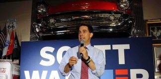 man speaking into a microphone at a campaign-style event