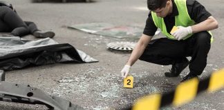 Forensic investigator marking evidence at crash scene