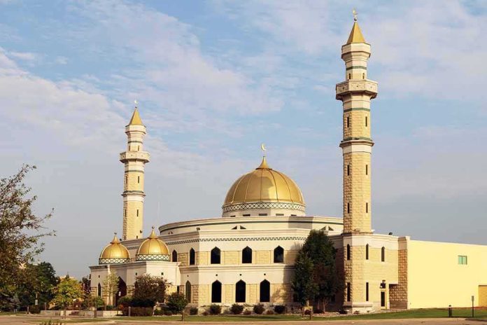Mosque with golden dome and two tall minarets under a partly cloudy sky