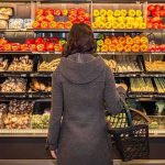 Woman shopping in a grocery produce aisle