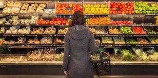Woman shopping in a grocery produce aisle