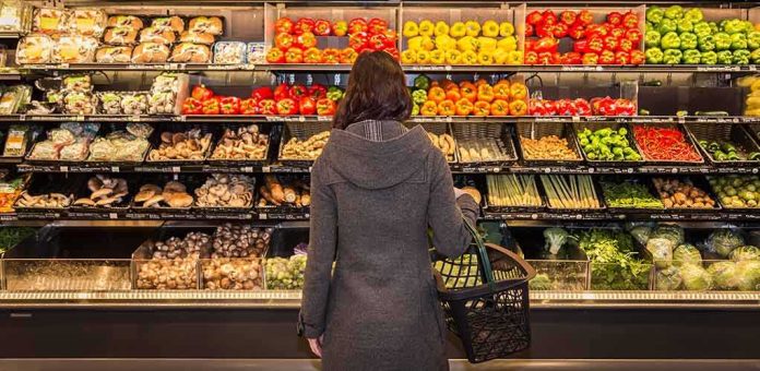 Woman shopping in a grocery produce aisle
