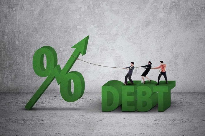 Three people pulling rope tied to rising percent sign beside large debt text
