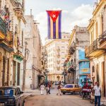 Cuban flag over colorful old Havana street