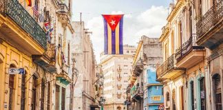 Cuban flag over colorful old Havana street