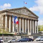 Neoclassical building with columns and French flags