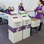 Dorota Kędzierzawska at a polling place with ballot boxes and election staff