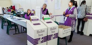 Dorota Kędzierzawska at a polling place with ballot boxes and election staff