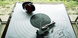 Revolver and ear protection on paper shooting target