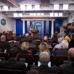 Rogue AI Breaches Spark Trump Firestorm Press secretary at podium addressing reporters in briefing room