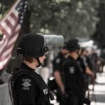 police officer in riot gear standing in a line