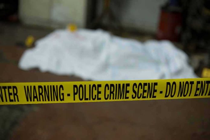 crime scene tape in foreground with covered body in background