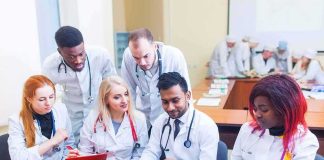 Group of medical students collaborating around a laptop
