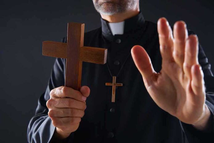 Clergyman holding wooden cross with hand raised