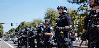 SWAT Officers Ambushed During Search Warrant Bear Pascoe, Brian Folkerts, and Eugene Sims among riot police standing in a line on a city street