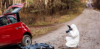 Husband’s ICE Story Unravels After Grisly Discovery forensic investigator photographing evidence near red car on dirt road