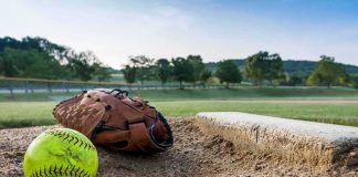 Parents Arrested After Violent Girls’ Softball Game Fight Softball and glove near a base on a dirt field