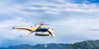 Flying Drone Carries Stranded Soldier To Safety Cargo drone helicopter flying over green mountain range