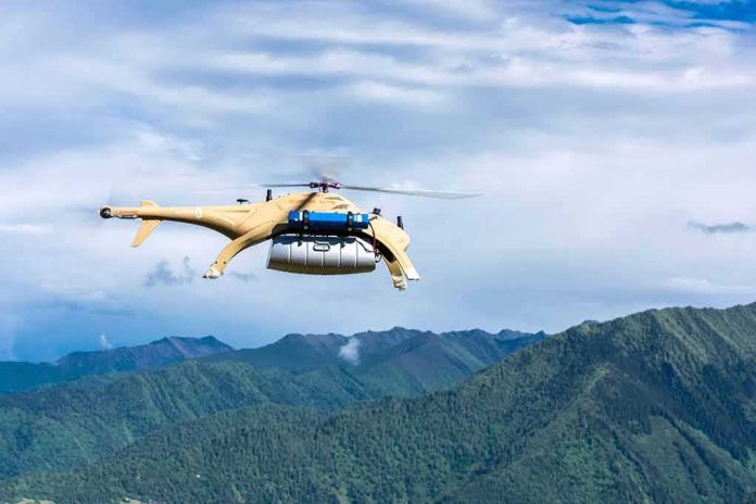 shutterstock_1432154513 Cargo drone helicopter flying over green mountain range