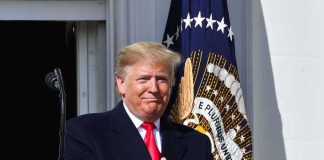 Trump Threat Suspect Claimed Rooftops Were Mapped Donald Trump clapping at a podium with the presidential seal