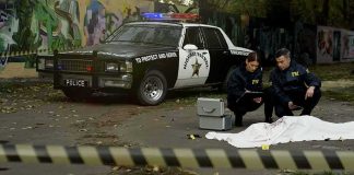 Iconic War Memorial Suffers Massive Damage Crime scene with police car and two investigators by a covered body
