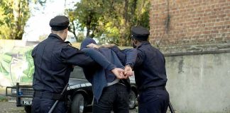 Kidnappers Get 20 Years After Victim Escapes police officers arresting a person against a wall outdoors