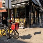 Delivery bicycle parked outside a corner deli