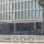 Embassy building behind tall black security fence