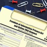 FOIA request form on a clipboard with office supplies