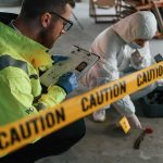 Police officer and forensic investigator at a crime scene behind caution tape