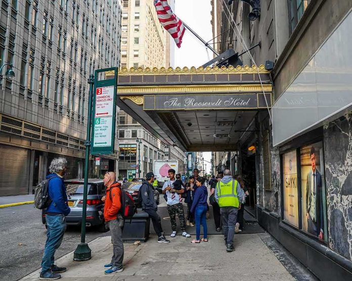 Andreas Hestler and pedestrians outside The Roosevelt Hotel entrance on a city sidewalk