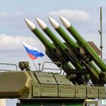 Russia Draws A Nuclear Red Line Surface-to-air missile launcher with green rockets and a raised Russian flag