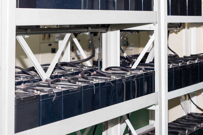 Rows of industrial batteries connected with cables in a storage facility
