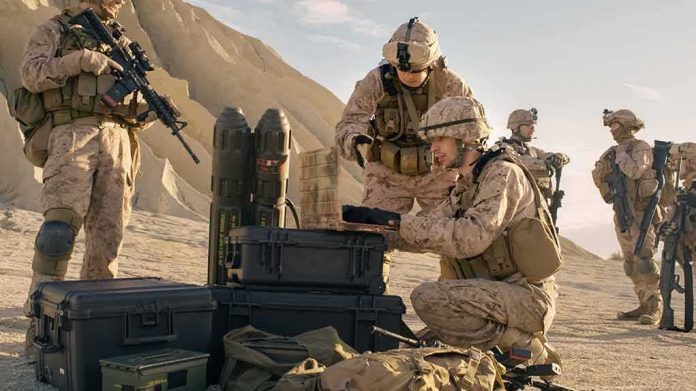 Soldiers in desert gear prepare equipment and rifles